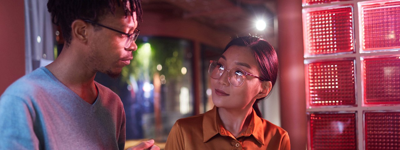 兩名同事站在一起交談  