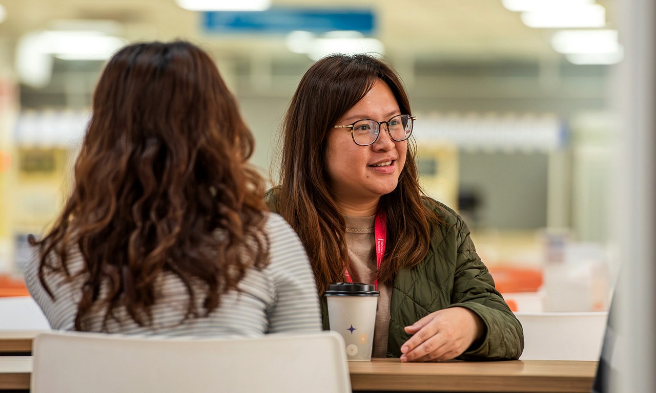Two women having a discussion over coffee